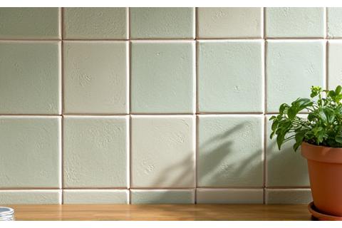 Close-up of a kitchen wall adorned with beautiful handmade ceramic tiles in a unique pattern and subtle colors.